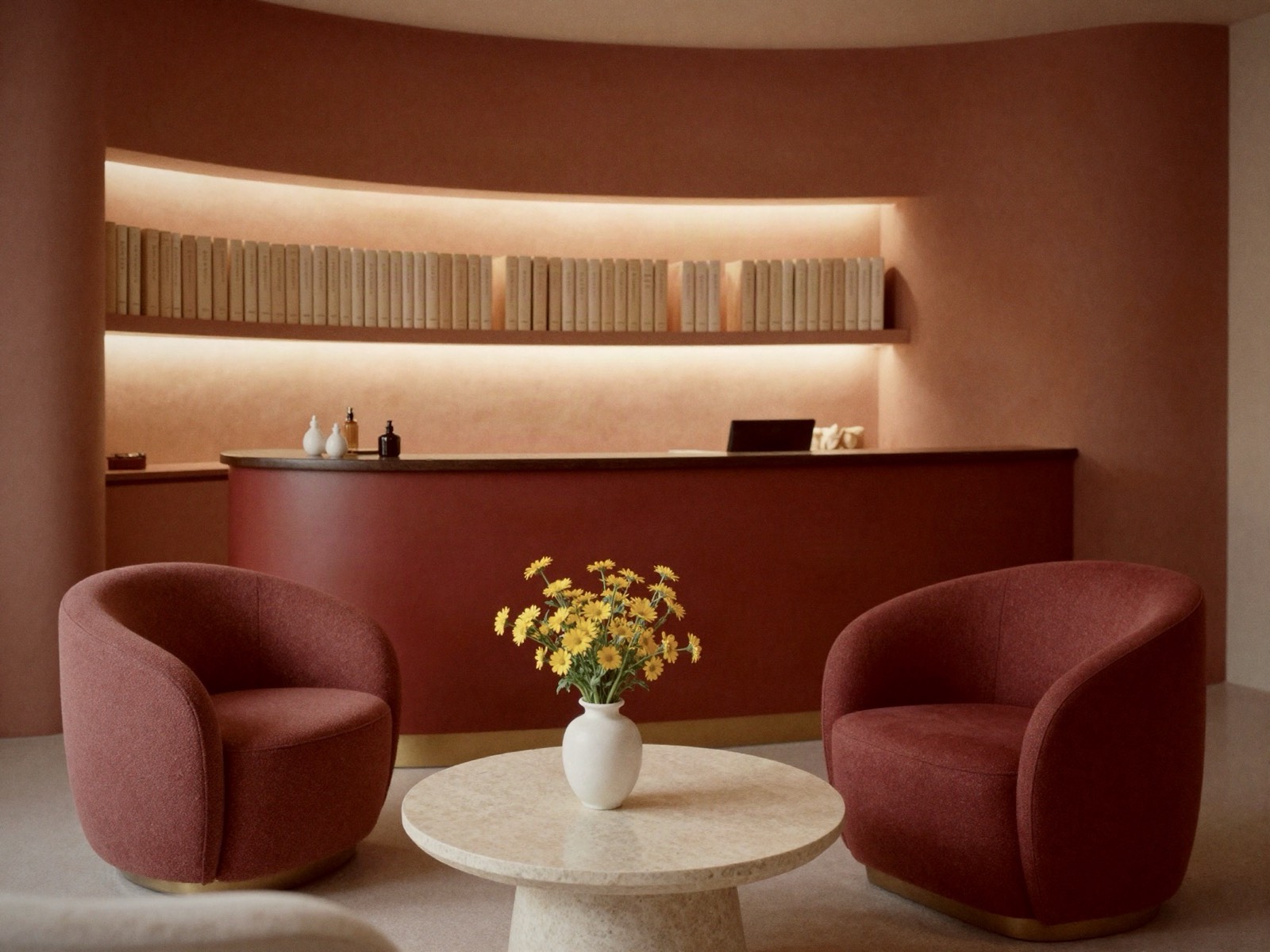 The Orris reception: a curved wine-red plaster wall with backlit shelves, boucle armchairs and a vase of yellow wildflowers.